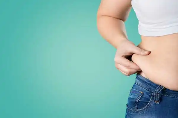 Image of woman pinching her love handles to show weight gain Blackburn